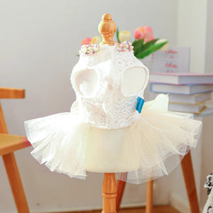 White lace dress with a tutu on a wooden mannequin against a neutral background