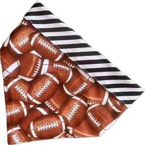 Handmade in the USA by Chloe & Max, this reversible Football Bandana features footballs, with white and black striped trim and backing.