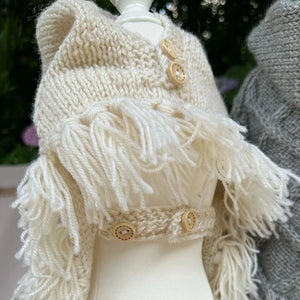 Hooded poncho attaches with button strap at the neck.
