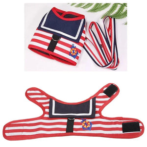 Red, white, and blue striped dog harness with anchor design on a white background.