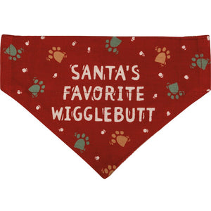 Christmas Reversible Dog Bandana has "Santa's Favorite Wigglebutt" sentiment with paw print designs on a red background on the other