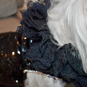 This handmade “Elektra” dress features glittering black sequins, silver beaded leather trim down the midline and cascading black lace at the neck.