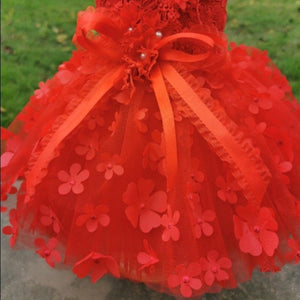 A red bow and 3-D flowers adorn this luxurious handmade red lace dog party dress, perfect for small dogs.