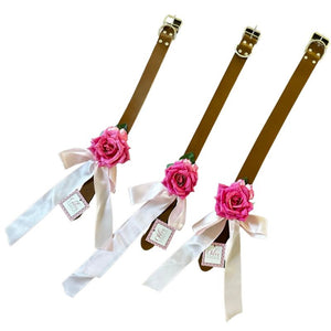 Perfect for weddings, this gorgeous pink rose on a brown leather collar has a light pink satin bow. Perfect for weddings, this gorgeous pink rose on a tan leather collar has a light pink satin bow.