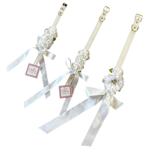 Perfect for weddings, these stunning white silk flowers on a faux white leather collar feature a matching white satin bow.
