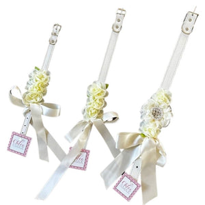 Perfect for weddings, these stunning cream silk flowers on a faux white leather collar feature a matching cream satin bow