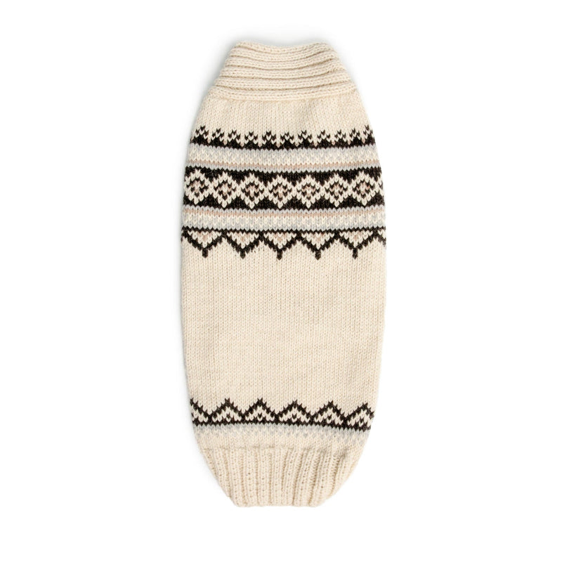 Dog wearing a knitted sweater with a pattern on a white background