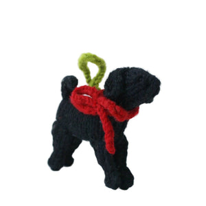 A Black Lab knitted ornament o with a red bow and a green loop on top, shown against a plain white background.