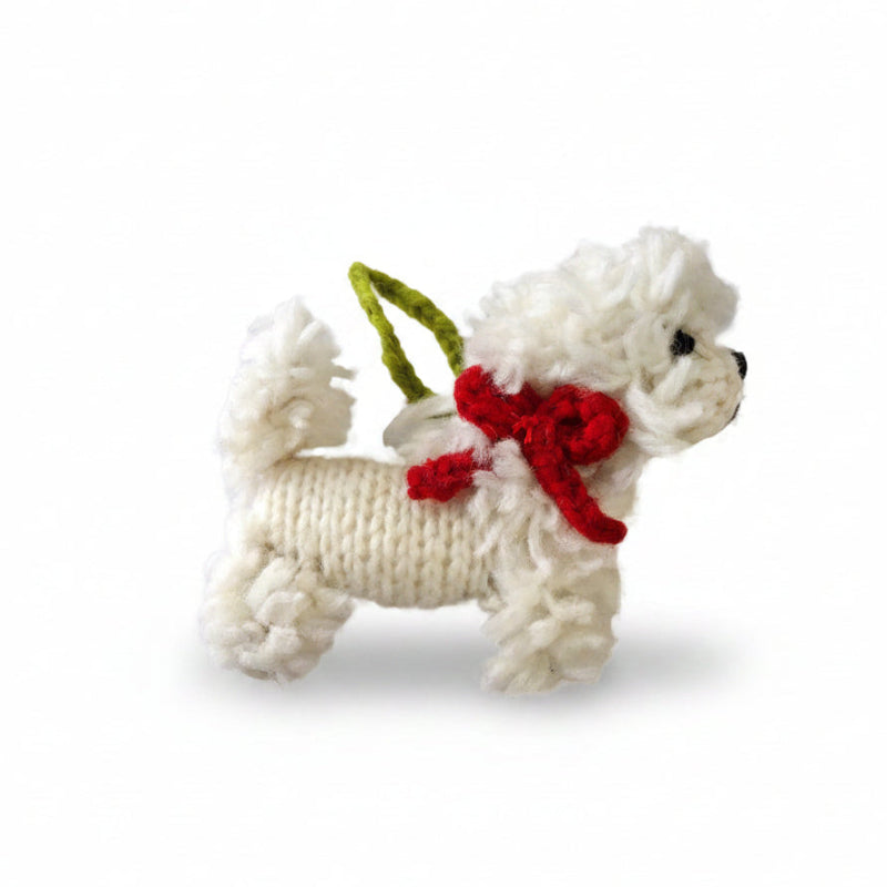 White knitted Bichon Frise ornament with a red bow on a white background