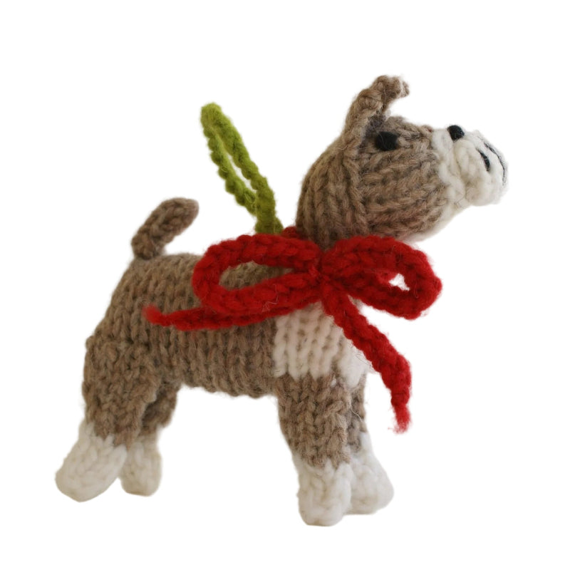 Knitted Boxer dog ornament with a red scarf and green tag on a white background