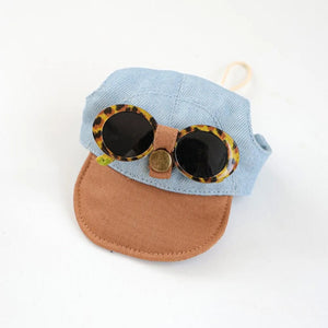 Small blue dog cap with sunglasses on top and a brown visor