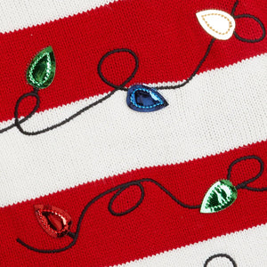 Close-up of a fabric with red and white stripes and embroidered Christmas lights