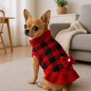 Chihuahua dog wearing a red and black checkered sweater with a bow in a living room.