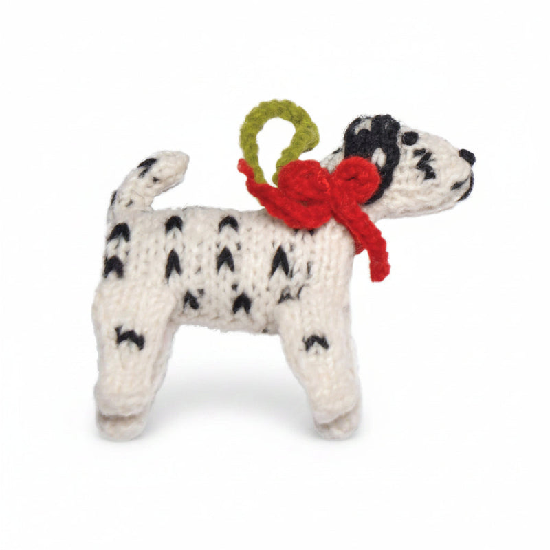 Knitted Dalmatian ornament with a red bow on a white background