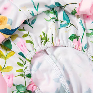 Floral-patterned romper with pink flowers and green leaves on a white background
