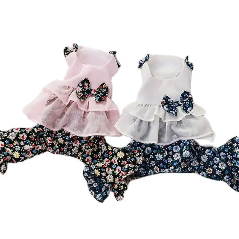 Two floral dog rompers in white and pink with floral patterns and bows on a white background