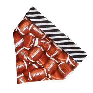Handmade in the USA by Chloe &amp; Max, this reversible Football Bandana features footballs, with white and black striped trim and backing.