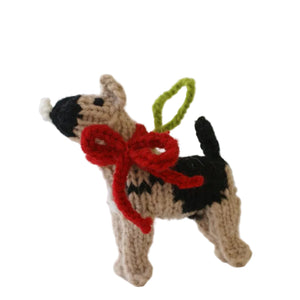 Knitted dog ornament with a red bow on a white background