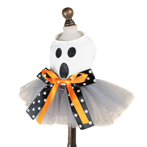 A ghost-themed pet costume displayed on a dress form mannequin. The costume features a white top with black glittery eyes and mouth, a gray tulle tutu skirt  and a large orange and black polka dot ribbon bow at the waist.