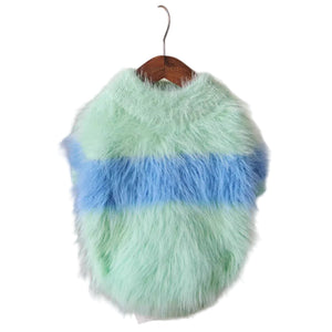 Green and blue fluffy dog sweater on a hanger against a white background