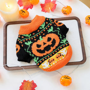 Halloween-themed dog sweater with pumpkins on a white surface with decorative elements.