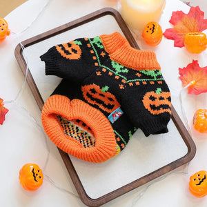 Halloween Pumpkin Dog Sweater featuring orange pumpkin and vine patterns on a black background, styled on a wooden tray with autumn decorations.