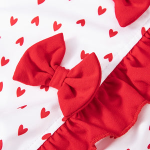 Red bow and ruffled design on a white background with red heart patterns