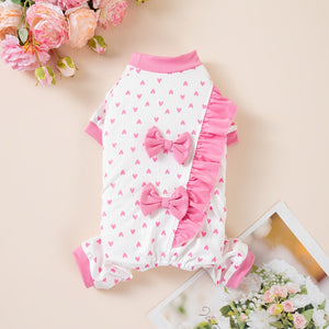 Pink and white pet outfit with bow details on a light background
