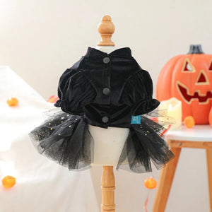 Black Halloween dog dress with puff sleeves on a mannequin against a Halloween-themed background.
