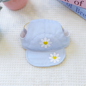 Light blue cap with daisy flower designs on a textured surface