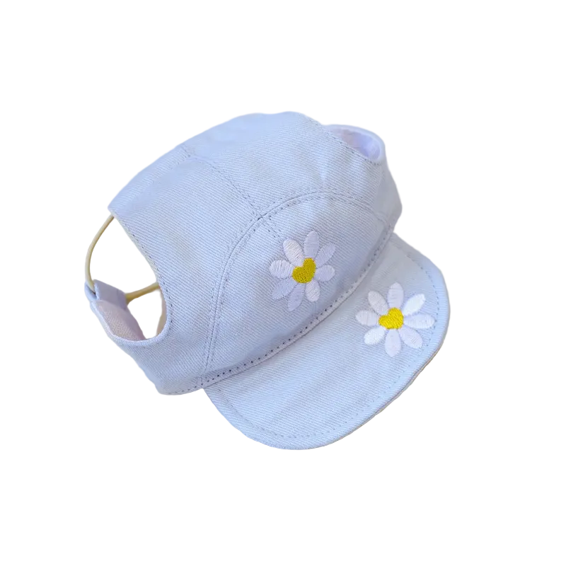 Light blue cap with white daisy flowers on a textured beige surface
