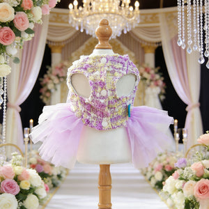 Lilac Dog Party Dress on a mannequin with floral wedding decorations and chandeliers in the background