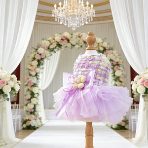Lilac Bloom Dog Party Dress on a mannequin with a floral arch and wedding arrangements in the background
