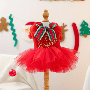 Red Christmas-themed dress with a bow on a wooden mannequin against a festive background.