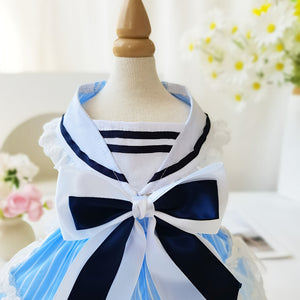 Nautical-themed dress in blue and whiteon a mannequin with flowers in the background