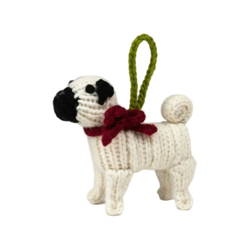 Crocheted dog ornament with a red bow tie on a white background