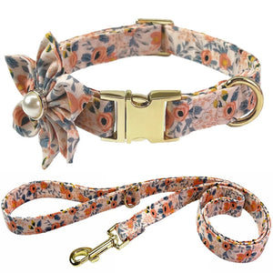 Floral dog collar and leash set with decorative bow and gold buckle on a white background