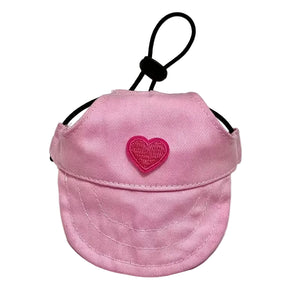 Pink visor with a heart-shaped logo on a white background