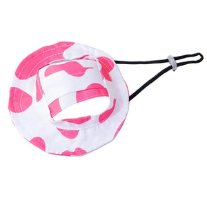 Pink and white cow patterned dog hat on a white background