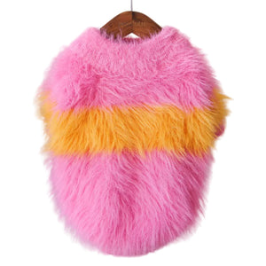 Fluffy pink and yellow dog sweater on a hanger against a neutral background