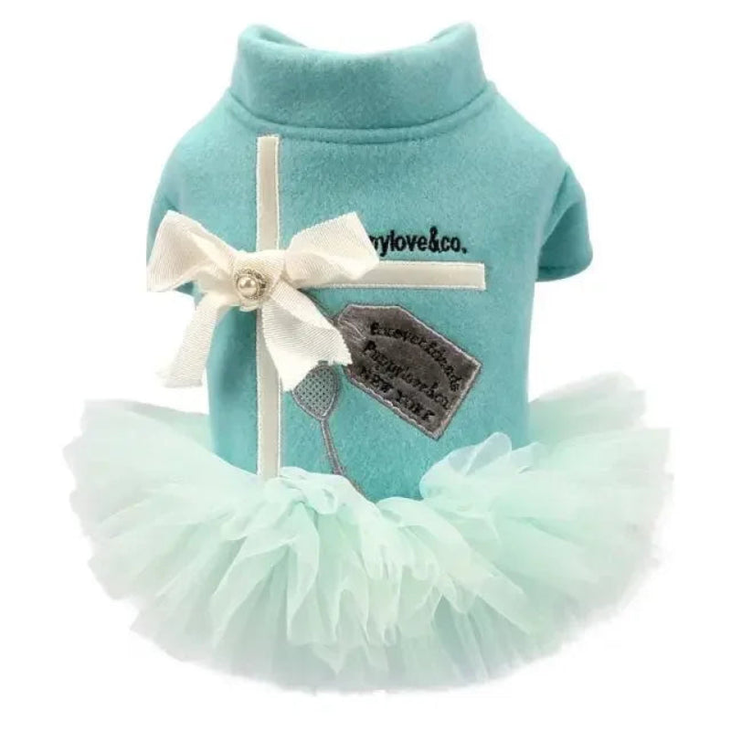 Teal dog dress with white bow and tag on a white background