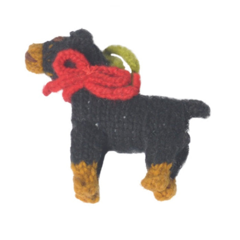 Knitted dog ornament with a red bow on a white background