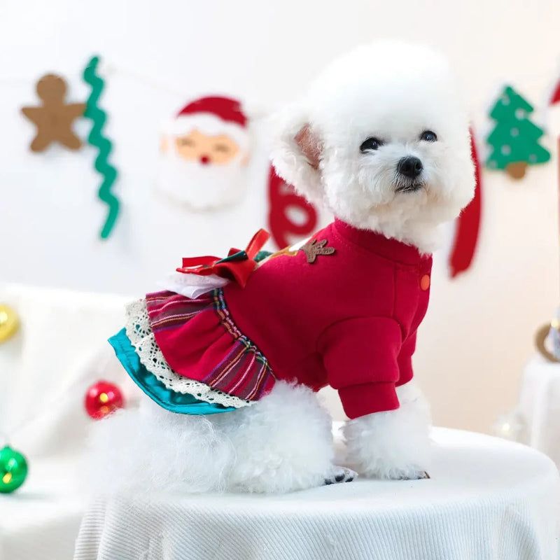 Red dog dress with reindeer design and bow on a white background