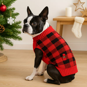 Boxer wearing a red and black checkered sweater in a festive setting with a Christmas tree and stockings.