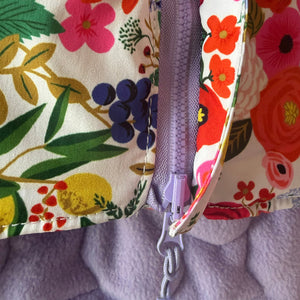 Zipper on reversible floral coat is on underbelly