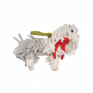 A handmade sheep dog ornament with shaggy white and gray yarn, a red felt bow, and an olive green leash, isolated on a white background.