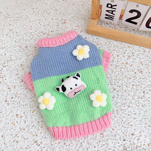 Spring Pastures Pastel Cow Sweater with Daisy Flowers is pastel pink, green and bllue.