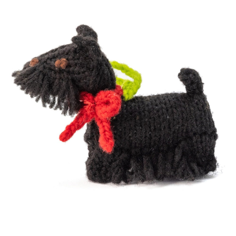 Black crocheted dog toy with a red bow and green tag on a white background