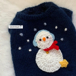 Navy blue dog sweater with a crocheted snowman applique on a white background