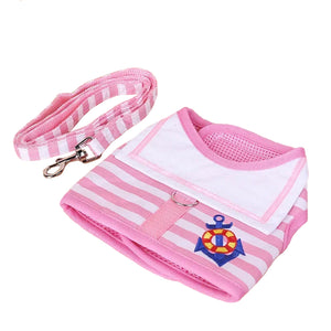 Pink and white striped dog harness with anchor design and matching leash on a white background